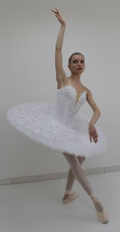 a young ballerina is posing for the camera