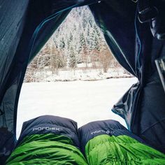 an open tent with the words down vs synthetic written on it in front of snow covered ground