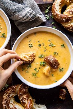 two bowls of soup with pretzels on the side