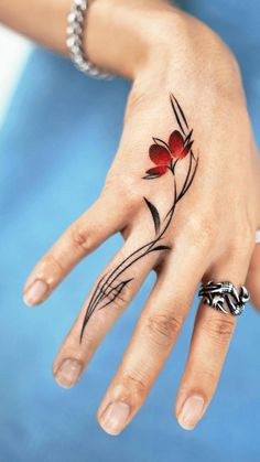 a woman's hand with a flower tattoo on it