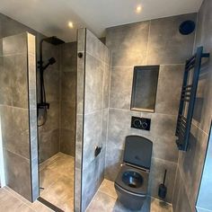 a bathroom with a walk in shower next to a toilet and a stand up shower