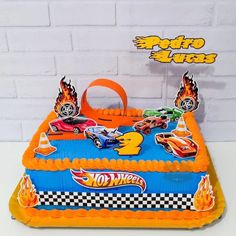 a birthday cake with cars on it is in the shape of a race car and flames