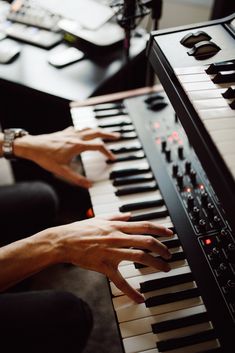 two hands are playing an electronic keyboard