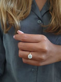 a woman wearing a diamond ring on her finger