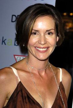 a woman in a brown dress smiling at the camera