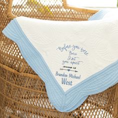 a blue and white blanket sitting on top of a wicker basket