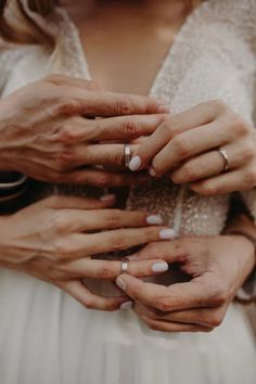 two people holding hands with wedding rings on their fingers