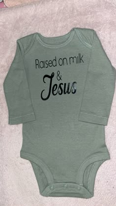 a baby bodysuit with the words raised on milk and jesus printed on it's chest