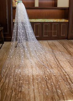 a wedding veil with stars on it is sitting in front of a wooden paneled wall