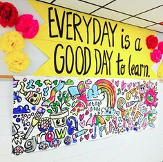 a classroom wall decorated with colorful paper flowers and an art project that says everyday is a good day to learn