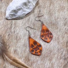 "Hand tooled earrings made from veg tanned leather and hand dyed in a soft tan color. Lightweight and flexible for all day wear.  Dimensions: 1.5\" earwire adds about .5\" to total length.  Materials: Veg tanned leather  Care: No not keep wet for long periods of time, remove before swimming or showering. Store hanging or laying flat.  Nickel and lead free ear post for sensitive ears  Each item is uniquely handcrafted and might have slight variations  Follow us on Instagram! https://www.instagram Bohemian Hand-tooled Leather Earrings, Artisan Brown Teardrop Earrings, Leather Teardrop Earrings For Everyday Use, Handmade Southwestern Leather Earrings, Adjustable Southwestern Brown Earrings, Artisan Brown Earrings For Pierced Ears, Rustic Hand Tooled Leather Earrings, Brown Bohemian Concho Earrings, Rustic Brown Leather Earrings