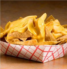 a basket filled with nachos covered in cheese