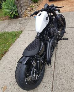 a black and white motorcycle parked on the sidewalk