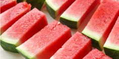 slices of watermelon are arranged on a white plate with blue and white checkered tablecloth