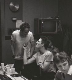 black and white photograph of four people in a recording studio