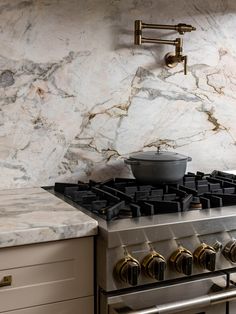 a stove top oven sitting inside of a kitchen next to a wall mounted faucet