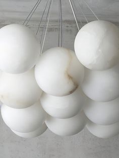 a bunch of white balls hanging from a ceiling