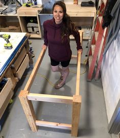 a woman standing next to a wooden frame