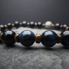 "Introducing our meticulously crafted Men's Beaded Bracelet, a fusion of style and substance. This gemstone bracelet features enchanting Blue Tiger's Eye stones, known for their striking hue and powerful energy. Designed as a minimalist bracelet, it effortlessly blends fashion with intentionality, making it the perfect choice for the modern man. Hand-strung on a durable stretch cord, this 6mm bracelet not only promises a comfortable fit but also symbolizes flexibility and strength. The sterling Blue Tiger Eye Stone, Healing Stone Bracelet, Tigers Eye Bracelet, Man Hand, Tiger Eye Gemstone, Powerful Energy, Tiger Eye Bracelet, Blue Tigers Eye, Tigers Eye Gemstone