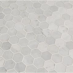 a white marble hexagonal tile pattern with grey grouting on the edges