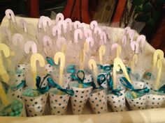 cupcakes are lined up in polka dot paper cups with blue ribbons and white umbrellas on them