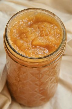 a glass jar filled with liquid sitting on top of a white cloth