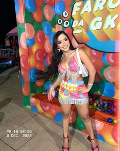 a woman standing in front of a fake gummy machine at the fairo de glo