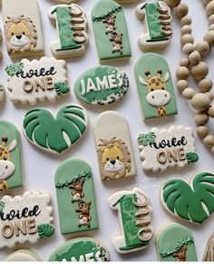 decorated cookies are arranged on a table for a baby's first birthday party with jungle animals