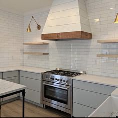 a stove top oven sitting inside of a kitchen next to a table and counter tops