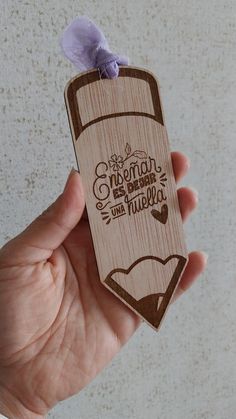 a person holding up a wooden tag with the words cinnamon and vanilla written on it