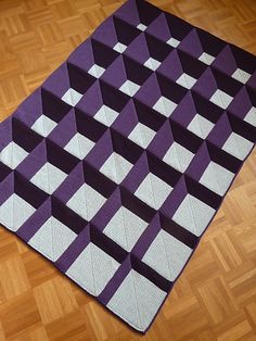 a purple and white rug sitting on top of a wooden floor