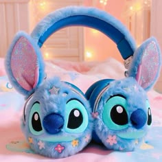 a blue stuffed animal ear muffs laying on top of a bed