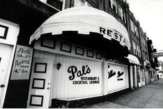 a black and white photo of an outside restaurant