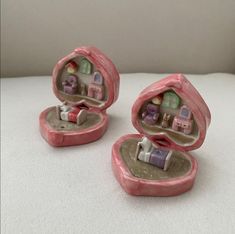 there are two small figurines in the shape of heart shaped boxes with furniture inside