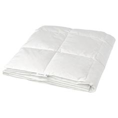 a white comforter is folded on top of a bed