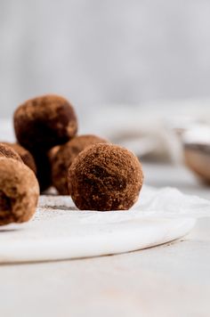 some chocolate donuts are on a white plate