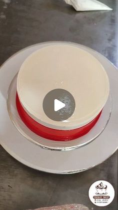 a white plate topped with a red and white cake