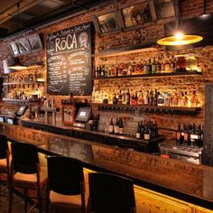 an empty bar with lots of bottles on the shelves