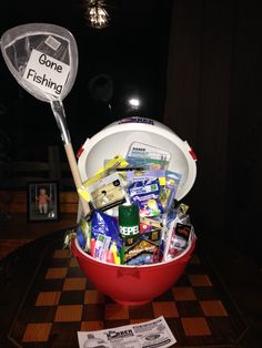 a bucket filled with assorted items sitting on top of a table