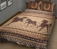 a bed covered in a brown and white quilt with horses on the cover, along with two framed pictures