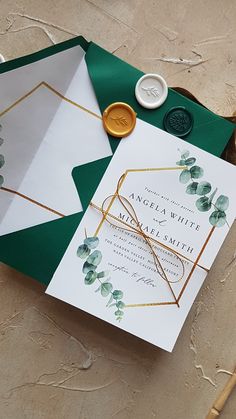 the wedding stationery is laid out on top of the envelopes and wax stamp