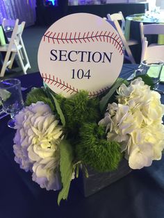 a baseball and hydrangeas on a table with the name section 104 written on it