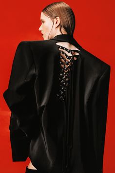 the back of a woman's black jacket with beaded details on her shoulders