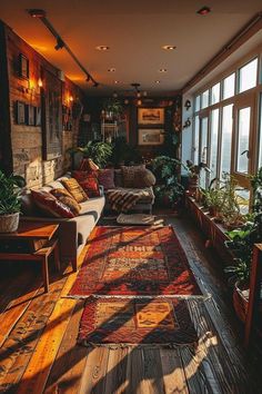 a living room filled with lots of furniture and plants next to large windows on the wall