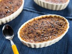 three dessert dishes with spoons on a blue cloth