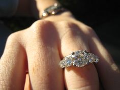 a woman's hand with a diamond ring on it