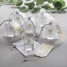 four personalized shot glasses and tags on a table