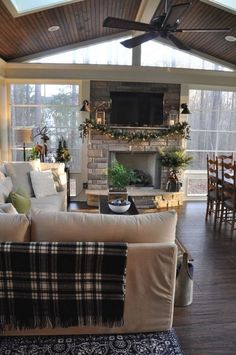 a living room filled with furniture and a flat screen tv mounted on the wall above a fireplace