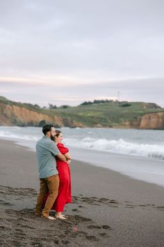 a man and woman embracing on the beach