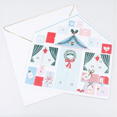 two envelopes with christmas designs on them sitting next to an envelope that is open